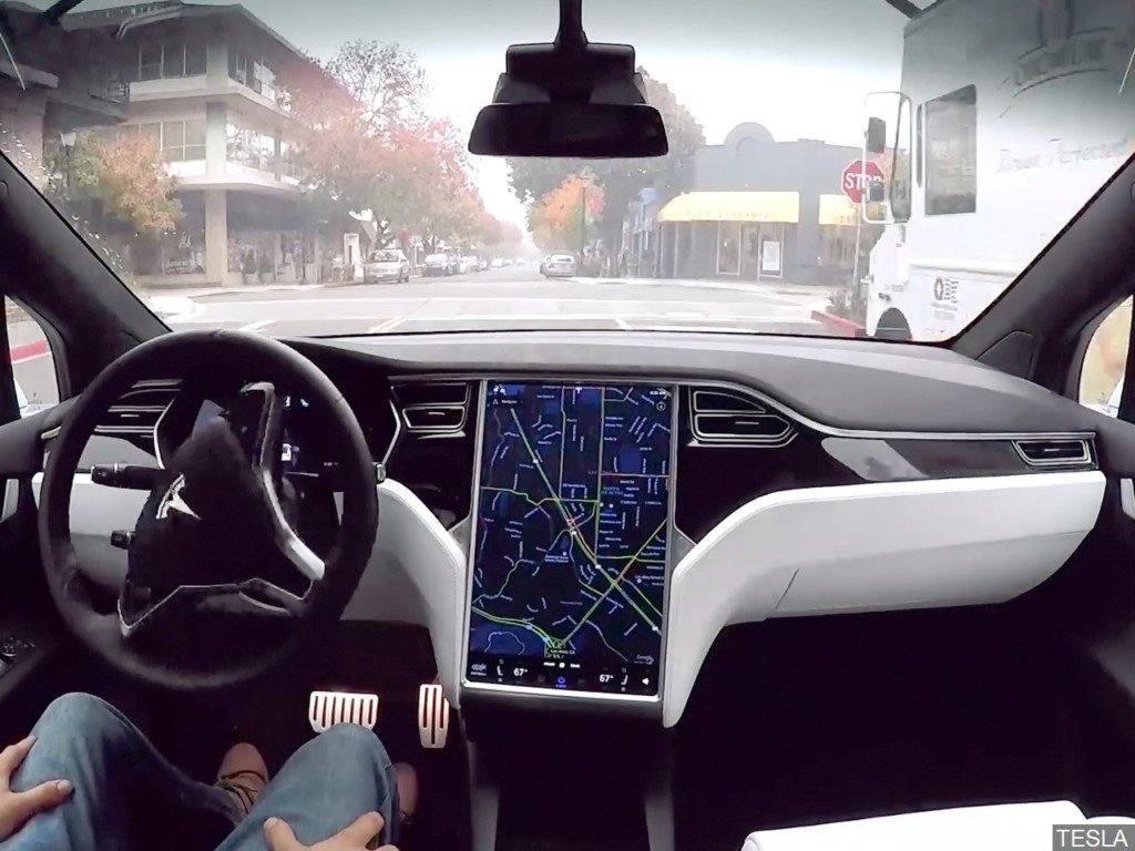 Ảnh minh hoạ người lái ngồi trong xe Tesla sử dụng hệ thống lái tự động Autopilot.