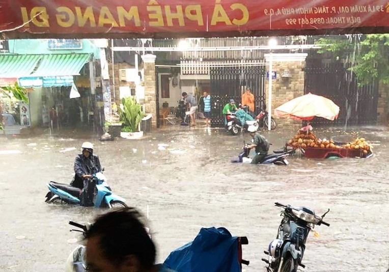 Nước ngập gần tới yên xe sau một cơn mưa trên đường Lã Xuân Oai (quận 9). Ảnh: Minh Quân
