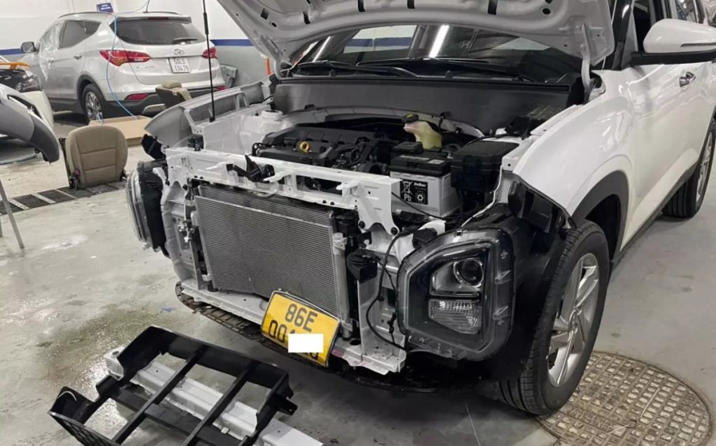 Chiếc xe nằm chờ sửa chữa tại đại lý Hyundai với phần hư hại nặng ở phía đầu xe.
