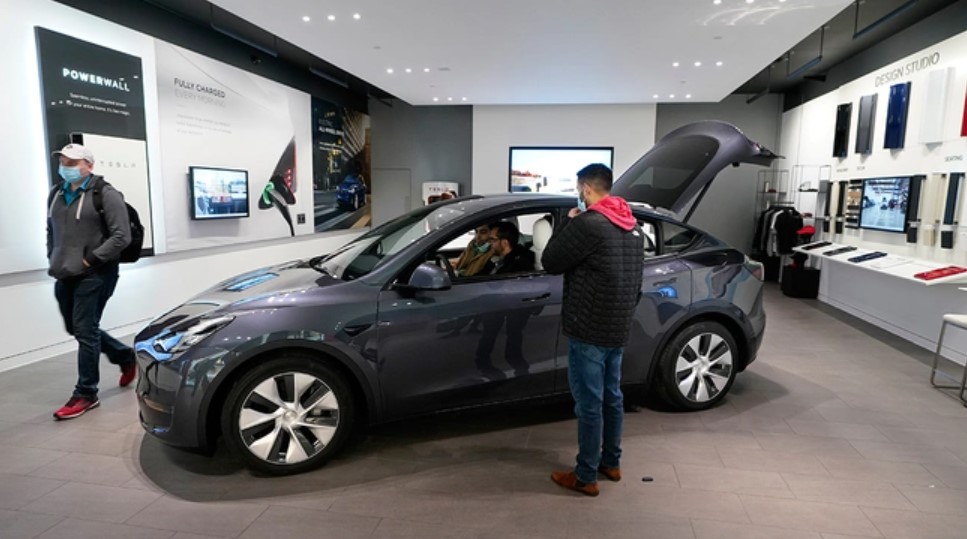 Khách tham quan tại quầy trưng bày xe của Tesla ở Michigan, Mỹ. Ảnh: Carlos Osorio/AP.